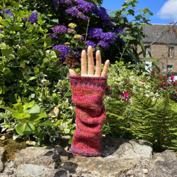 Hand knitted wrist warmers on hand