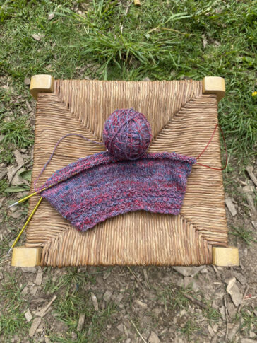 A handmade hat, tricot sur chaise en paille