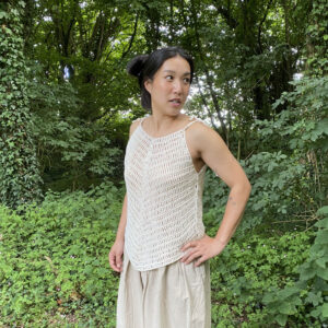 Crochet top Perle modelé par Steph sur fond de verdure