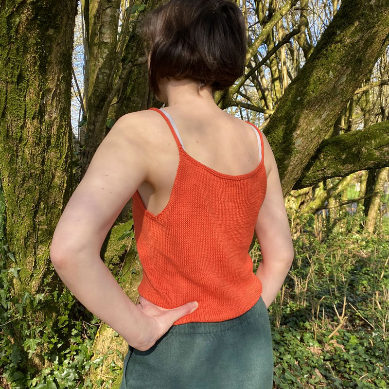 Vue de dos du Crop top Corail sur modèle Léna, en pleine nature, la laine de Galeine